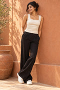 Square Neck Rib Tank Top in Coconut Milk – leaning on a terracotta wall