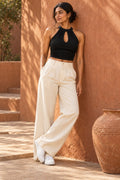 Halter Keyhole Crop Top in Jet Black – leaning on a terracotta wall