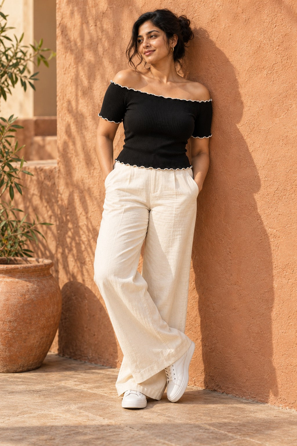 Off Shoulder Lettuce Edge Rib Top in Jet Black – leaning on a terracotta wall