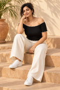 Off Shoulder Lettuce Edge Rib Top in Jet Black – seated on steps