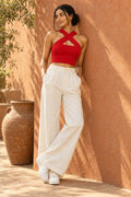 Cross Neck Rib Crop Top in Fiery Red – leaning on a terracotta wall