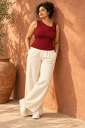 Twist Shoulder Rib Top in Emboldened – leaning on a terracotta wall
