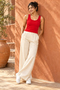 Scallop Neck Rib Tank Top in Fiery Red – leaning on a terracotta wall