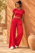 Rib Crop Top & Wide Leg Pant Set in Cranberry – leaning on a terracotta wall