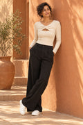 Twist Front Keyhole Rib Top in Coconut Milk – leaning on a terracotta wall